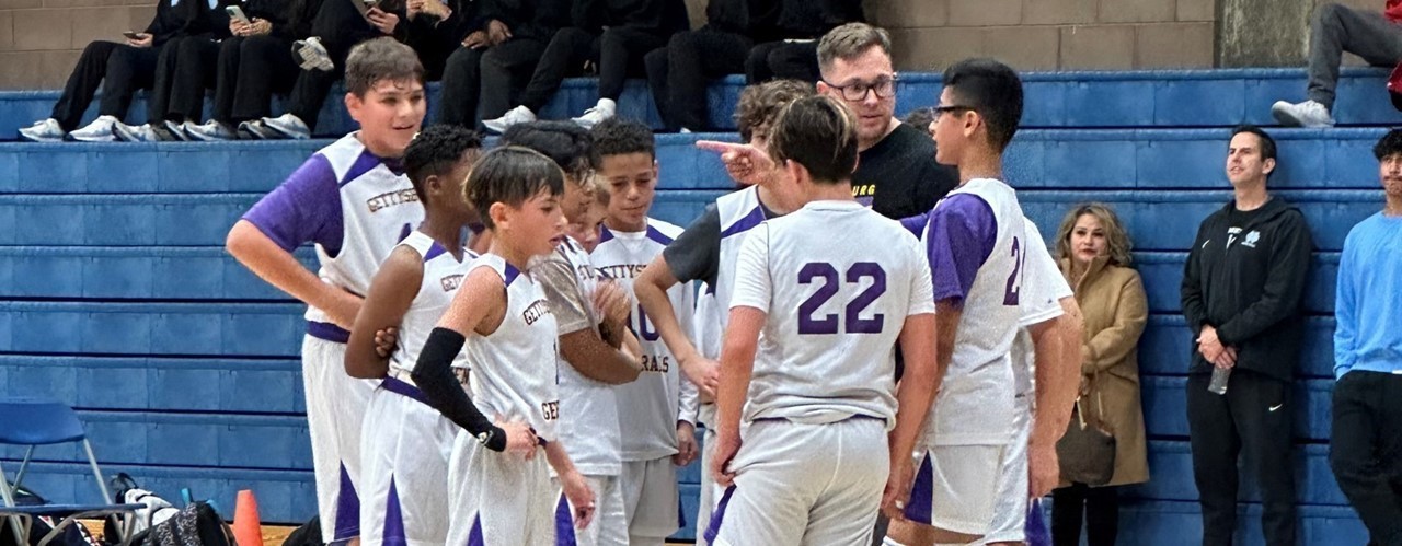 Players and coach in a basketball huddle